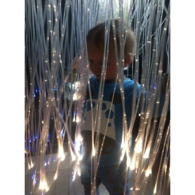 Et barn udforsker en Fiberglow med lysstrenge